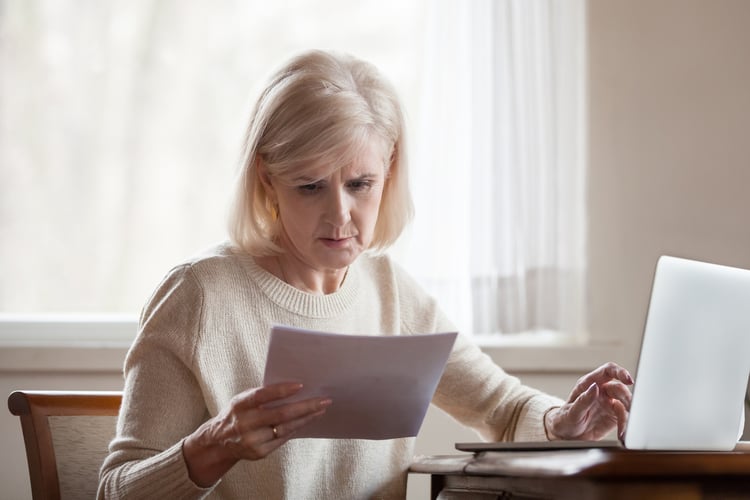 Senior looking at bills and feeling stressed.